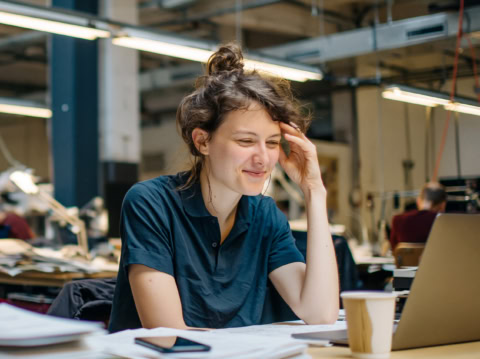 Wartungsplanerin am Schreibtisch beim Aufsetzen eines digitalen Wartungsplans
