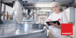Mitarbeiterin in der Lebensmittelproduktion von backaldrin mit Tablet
