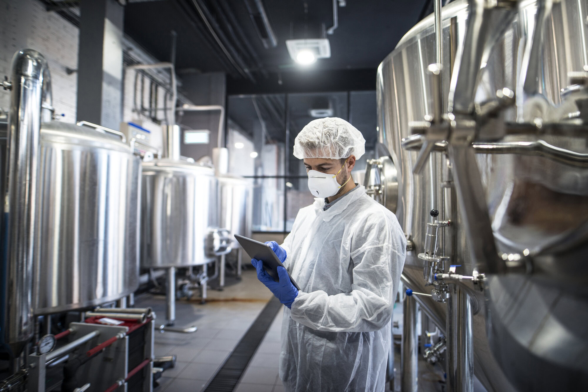 technologist white protective clothes checking production his tablet scaled